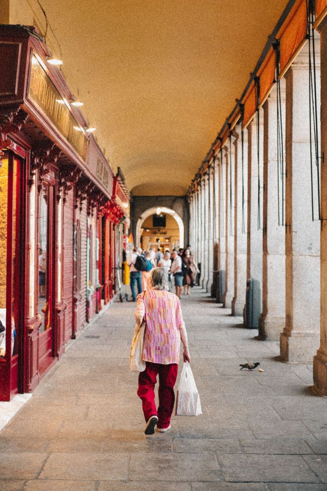 Back of a woman walking under an arched walkway