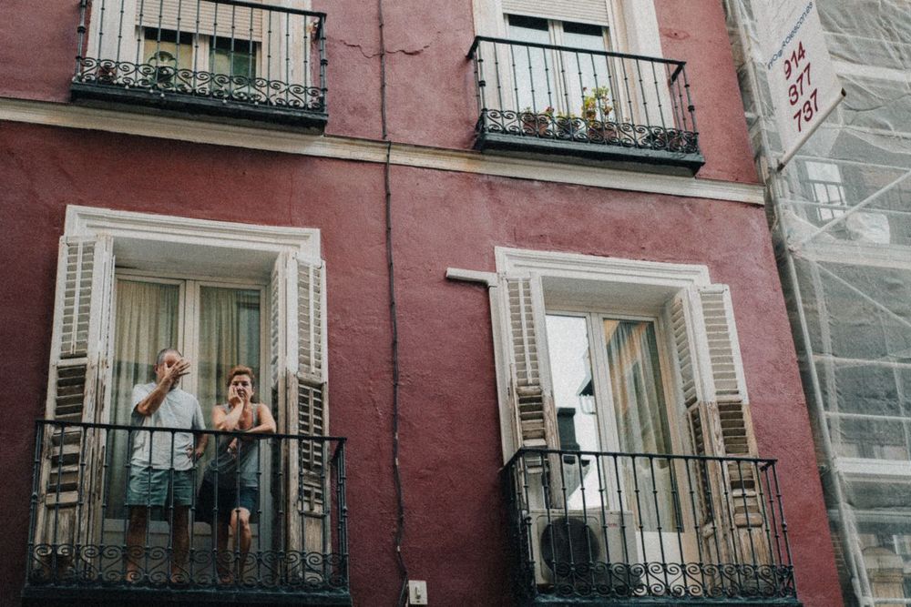 Two people chatting across neighboring balconies.